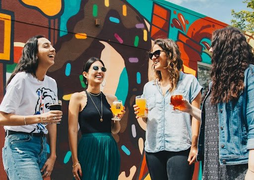 A group of friends is hanging out outside and socializing after moving to a new city.